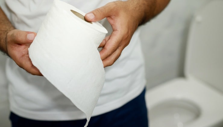 Mann mit Toilettenpapierrolle in der Hand