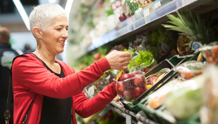 Frau liest Etikett im Supermarkt